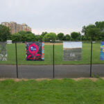 Four artworks hanging from a chain-link fence in Oxon Run Park, Washington, DC
