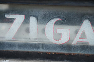 The letters ZIGA on the front of a zigarillo vending machine.