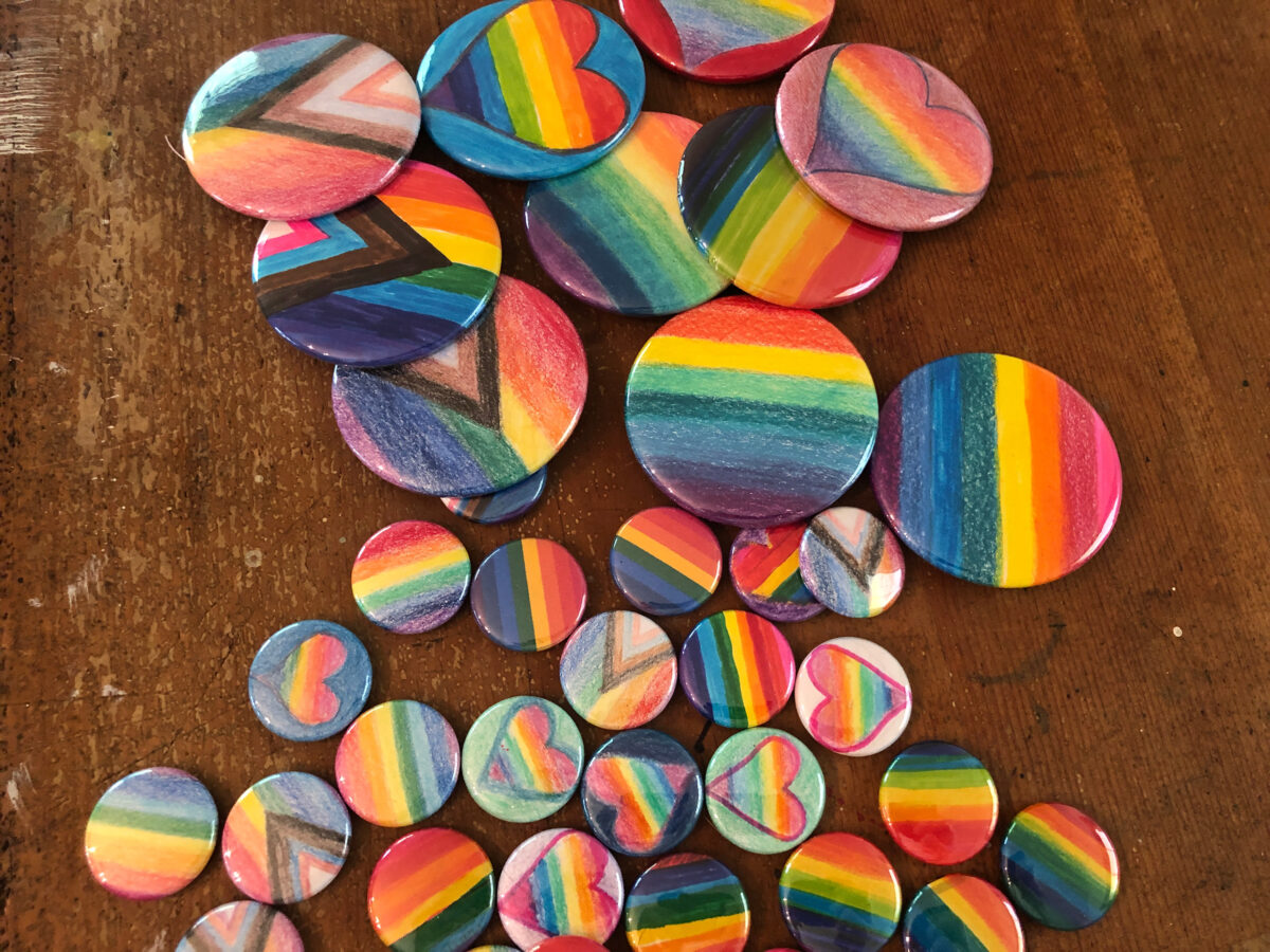 Pride buttons on a wooden surface